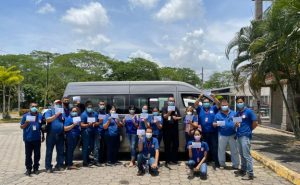 The Siempre Unidos staff hold their vaccination certificates.